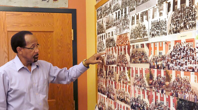 Eddie Charmbers, retired and former director of the Wittenberg Upward Bounds program, looked over the pictures on his old office wall, of all the students who’ve come through program over the years. The pre-college preparatory program is accepting applications for new students. Bill Lackey/Staff