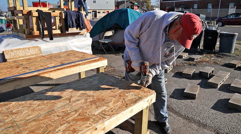 Efforts at the West Main Street encampment were ongoing before city workers and other organizations dismantled the site. A volunteer, Al Hayden, made a bed last week so the people living in tents at the encampment didn't have to sleep on the cold ground this winter. BILL LACKEY/STAFF