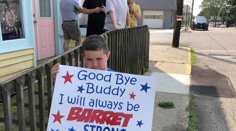 Reese Carter holds a sign supporting his friend and classmate, Barrett Fitzsimmons, who lost his battle with cancer Tuesday. Carter was one of several community members who lined the streets of the village of North Hampton as Fitzsimmons funeral procession passed on Saturday. BRETT TURNER / CONTRIBUTED