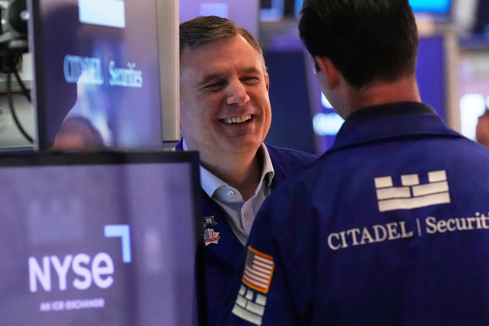 Specialist Thomas Schreck, left, talks with a colleague on the floor of the New York Stock Exchange, Friday, April 11, 2025. (AP Photo/Richard Drew)