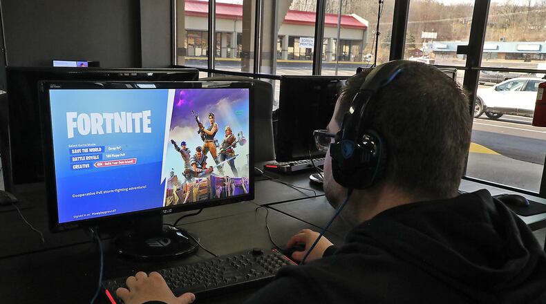 A customer gets ready to play Fortnite on a PC at Pixel Playground’s new location in The Shops at Upper Valley Pike Monday. BILL LACKEY/STAFF