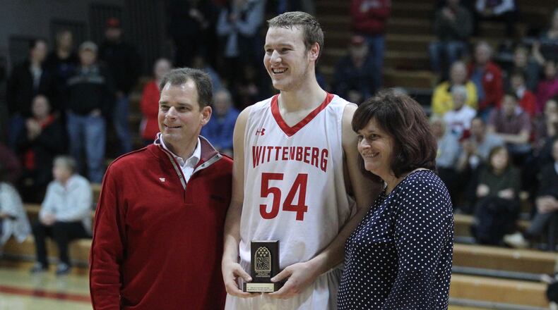 Wittenberg’s Connor Seipel, center, holds the NCAC tournament MVP trophy as he poses for a photo with Wittenberg President Michael Fransden and NCAC Executive Director Keri Alexander Luchowski after a victory against Ohio Wesleyan on Saturday, Feb. 24, 2018, at Pam Evans Smith Arena in Springfield. David Jablonski/Staff