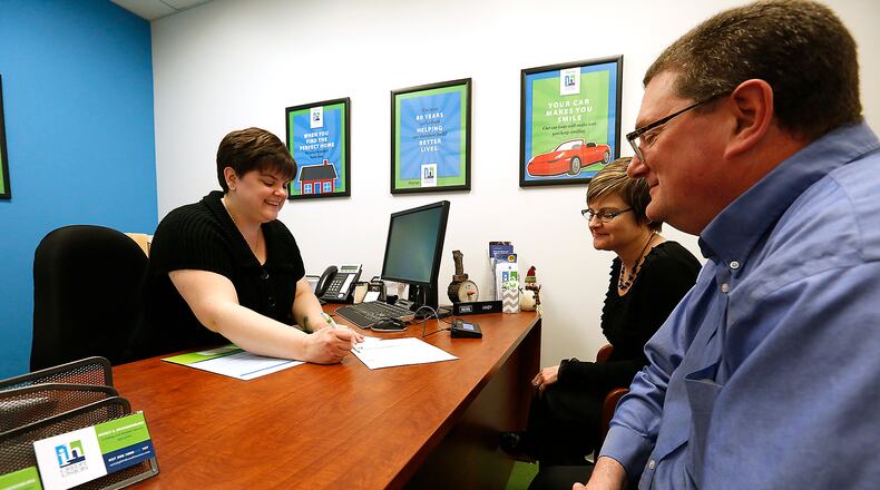 In this file photo an IH Credit Union employee talks about checking accounts with a customer in March, 2016. Bill Lackey/STAFF