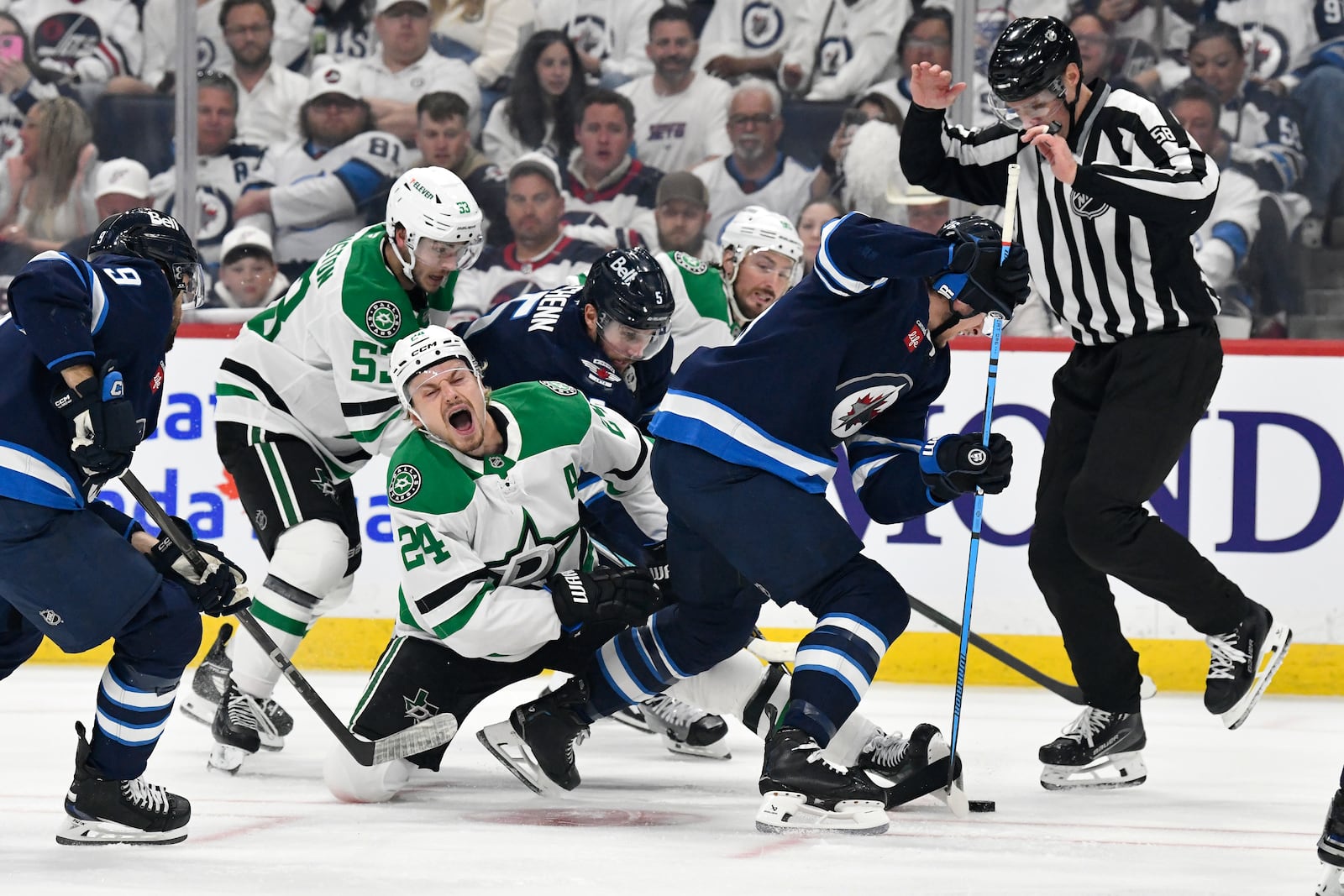 Dallas Stars' Roope Hintz (24) reacts after a face-off against Winnipeg Jets' Morgan Barron (right) during first period NHL playoff hockey action in Winnipeg, Thursday, May 15, 2025. (Fred Greenslade/The Canadian Press via AP)