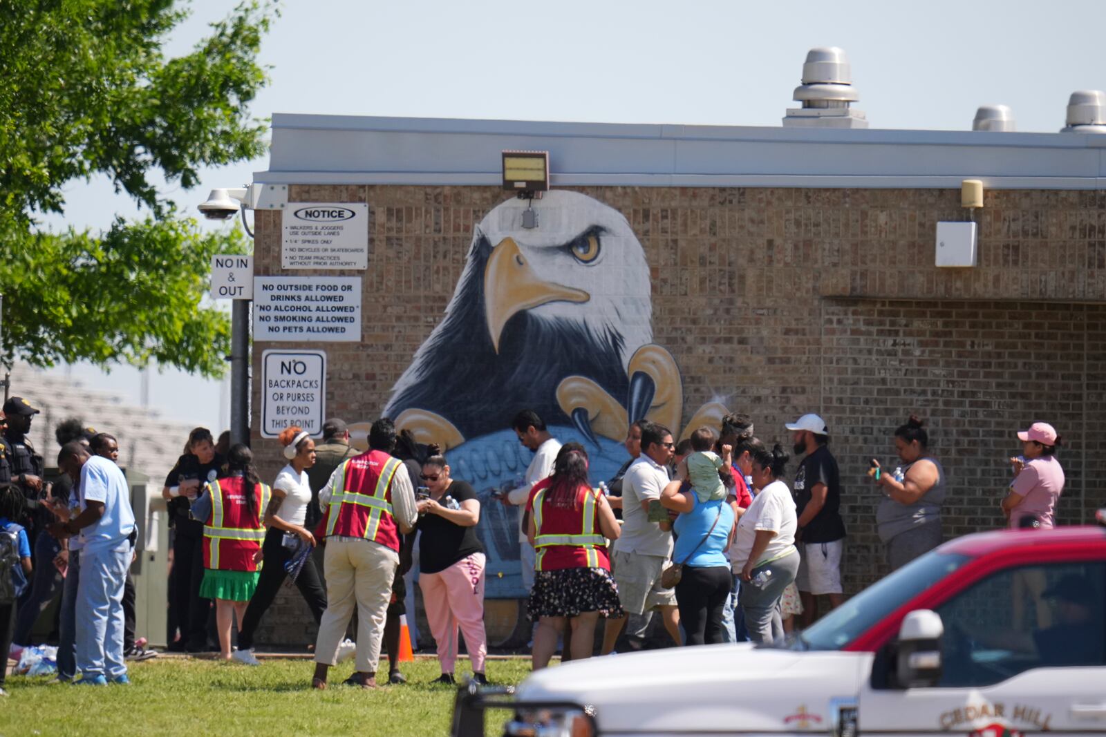 Parents are checked in to pick up their children at Wilmer-Hutchins High School, where police are responded to reports of a shooting at in Dallas, Tx., Tuesday, April 15, 2025. (AP Photo/Julio Cortez)