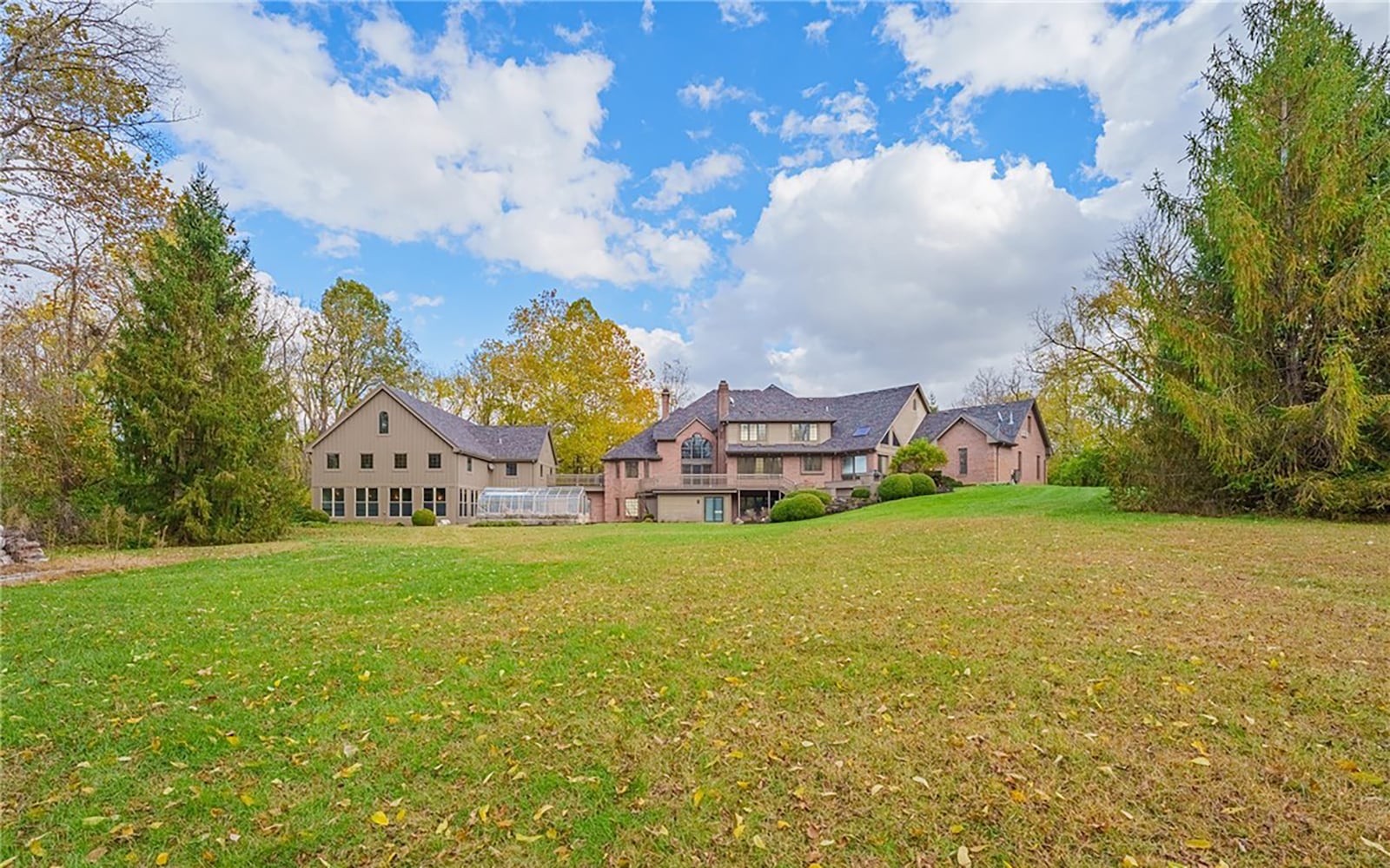 The custom estate home sits on 10.1 acres in Troy. The rear has extensive patios and walkways and a multi level wood deck. The property is mostly wooded and has a creek. CONTRIBUTED