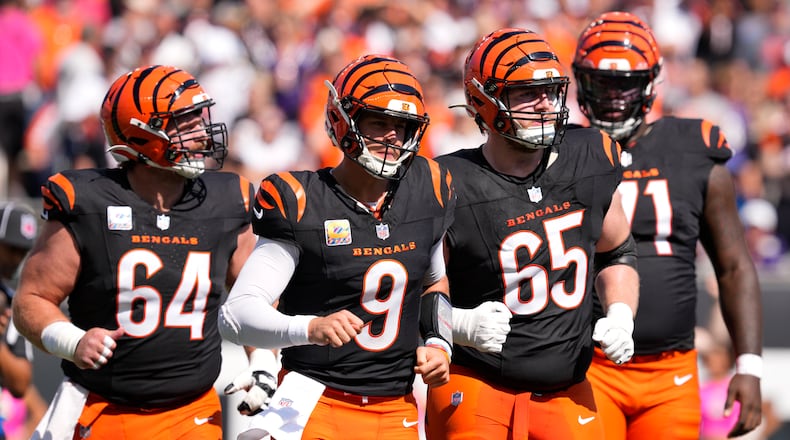 Cincinnati Bengals quarterback Joe Burrow (9) leaves the field with center Ted Karras (64), guard Alex Cappa (65) and offensive tackle Amarius Mims (71) after a series against the Baltimore Ravens during the first half of an NFL football game, Sunday, Oct. 6, 2024, in Cincinnati. (AP Photo/Jeff Dean)