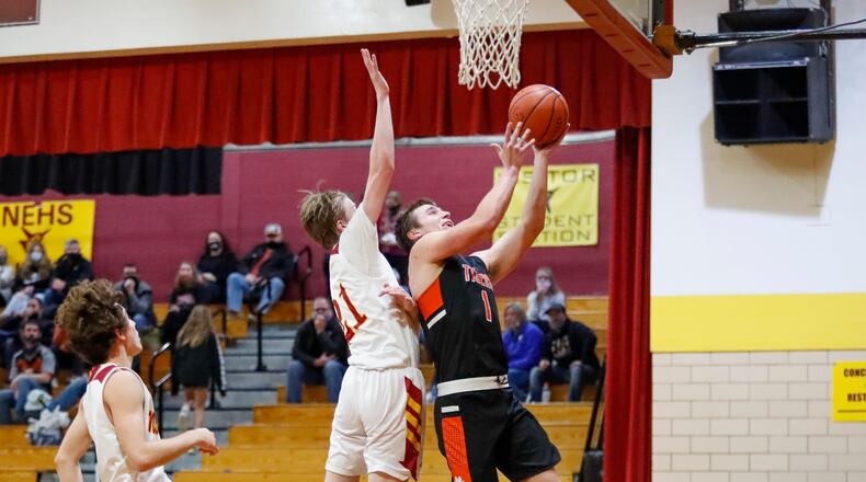 WLSbbk1: West Liberty-Salem High School senior Nick Burden shoots a layup over Northeastern's Adam Webb during their game on Tuesday night in Springfield. The Tigers won 65-45. CONTRIBUTED PHOTO BY MICHAEL COOPER