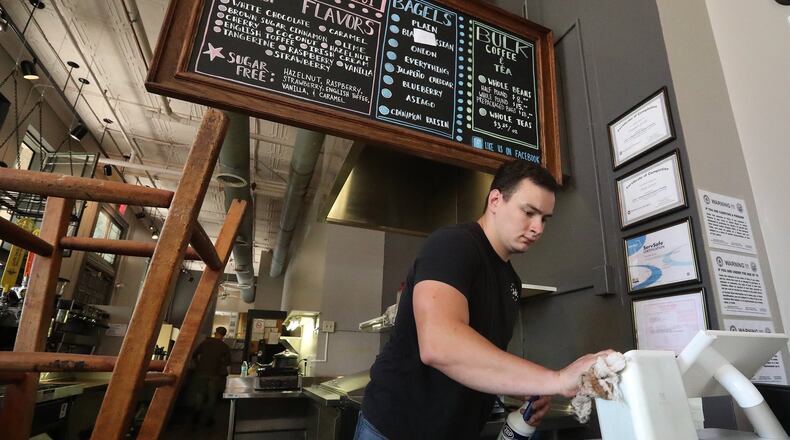 Stephen Level and the crew at Un Mundo Cafe cleaning Monday as they get ready for their grand reopening on June 7. Un Mundo was closed for over a month due to water damage from a broken pipe on the third floor of the Clark County Heritage Center. BILL LACKEY/STAFF