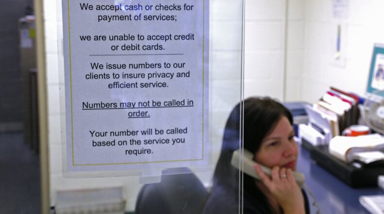 A sign on the reception window at the Clark County Combined Health District lets people know they only are accepting cash or checks now. Bill Lackey/Staff