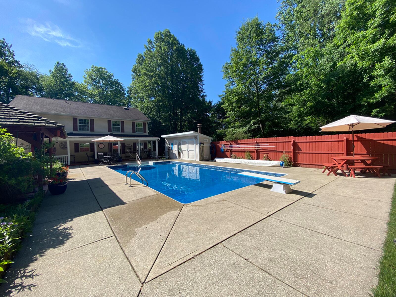 The rear yard has an in-ground pool with diving board, covered back deck, privacy fence, pool house and detached, 1-car garage with a workshop and separate apartment. CONTRIBUTED PHOTO