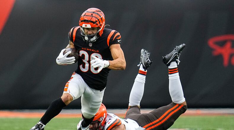Cincinnati Bengals running back Chase Brown (30) escapes from Cleveland Browns linebacker Jordan Kunaszyk (51) during the first half of an NFL football game in Cincinnati, Sunday, Jan. 7, 2024. (AP Photo/Sue Ogrocki)