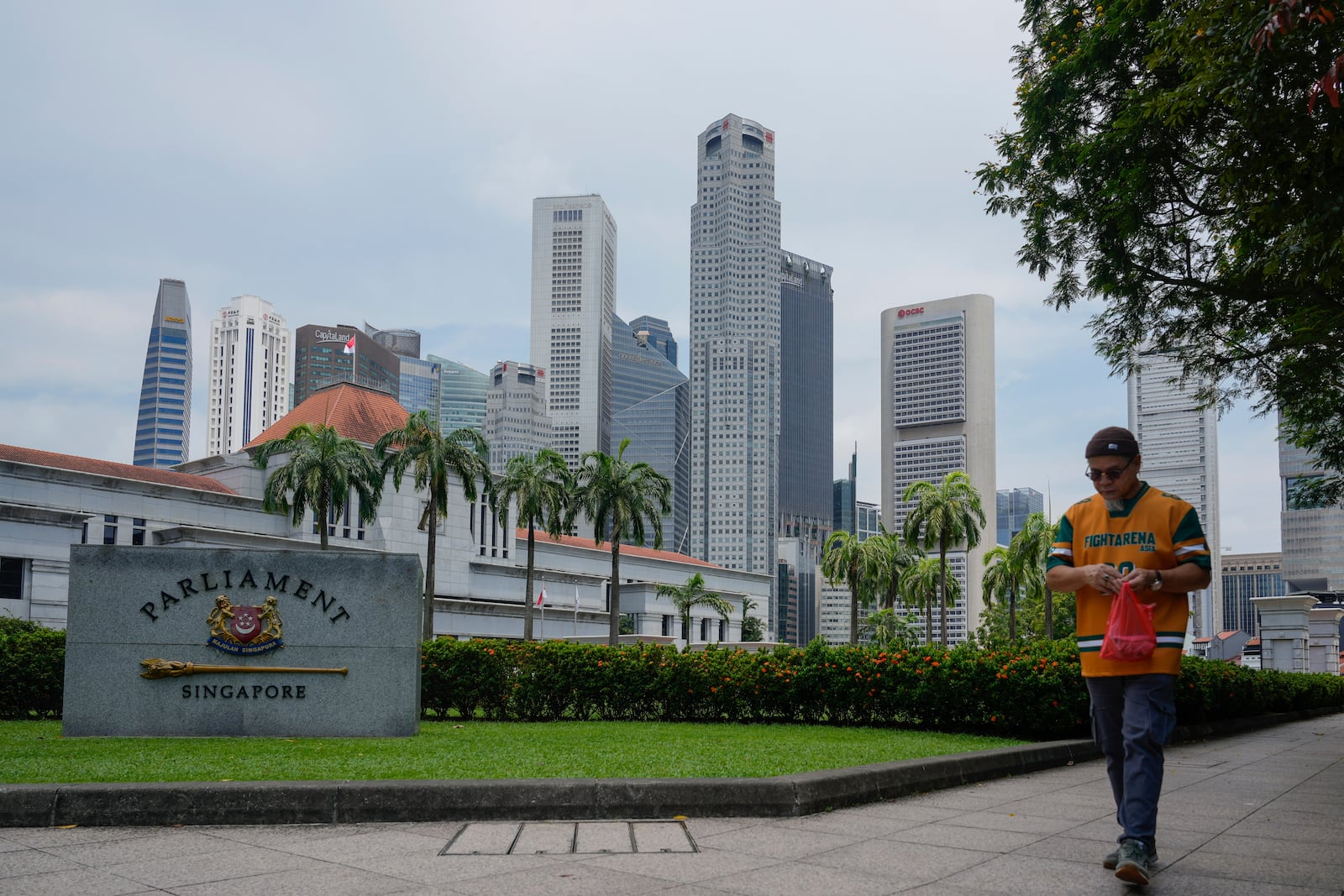 Pedestrian walks in front of the parliament building in Singapore, Friday, May 2, 2025. (AP Photo/Vincent Thian)