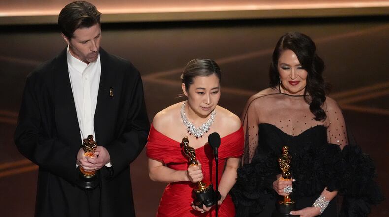 Chris Appelhans, from left, Maggie Kang, and Michelle L.M. Wong accept the award for animated feature film for "K-pop Demon Hunters" during the Oscars on Sunday, March 15, 2026, at the Dolby Theatre in Los Angeles. (AP Photo/Chris Pizzello)