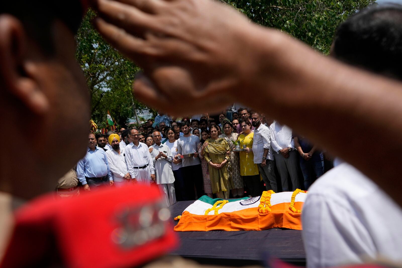 Police personnel pay tribute to Raj Thapa, a senior bureaucrat who was killed in Pakistani shelling in Rajouri, at his funeral in Jammu, India, Sunday, May 11, 2025. (AP Photo/Channi Anand)