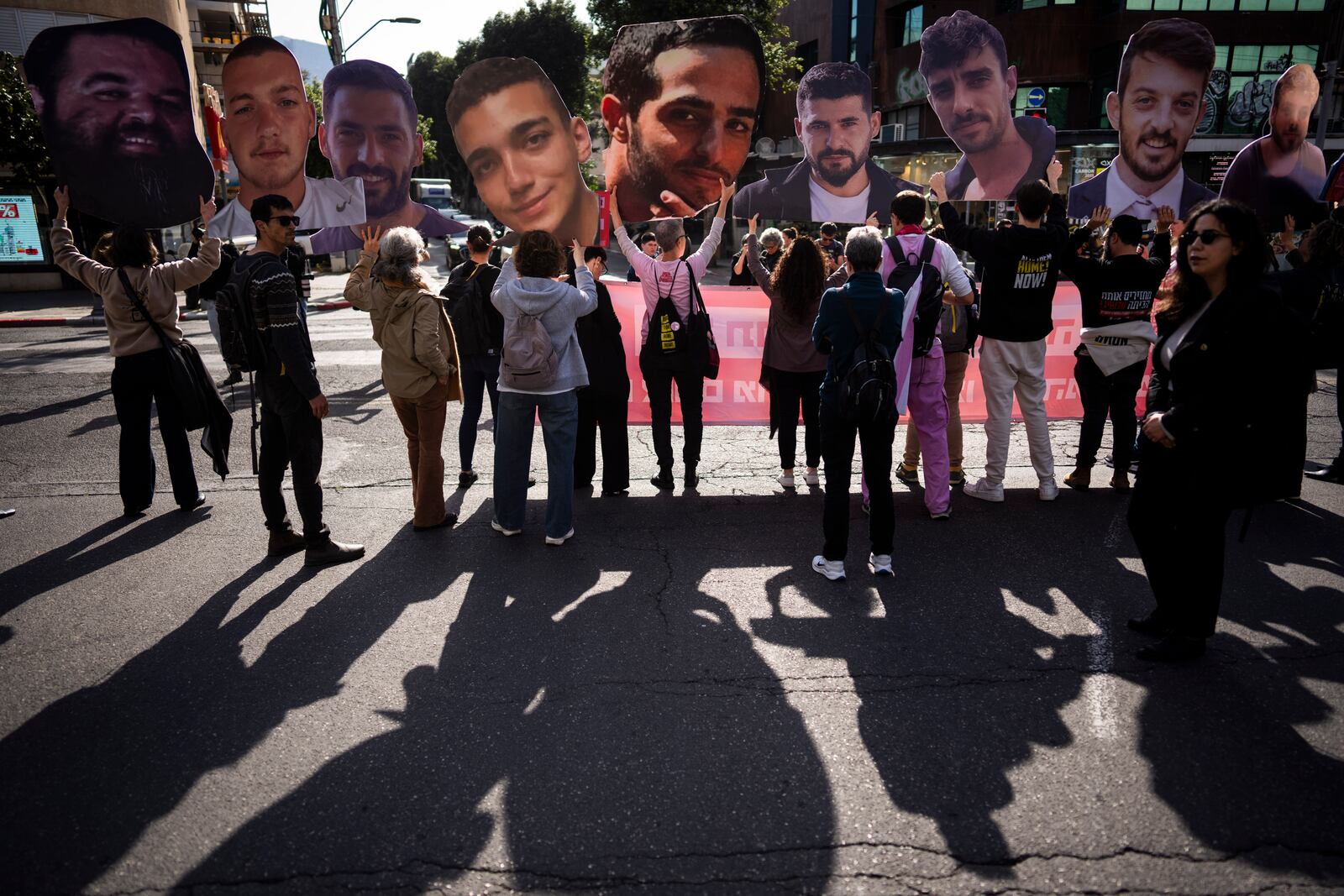 Demonstrators hold photos depicting the faces of Israeli hostages who are being held in the Gaza Strip, during a protest demanding their release from Hamas captivity, in Tel Aviv, Israel, Thursday, March 6, 2025. (AP Photo/Oded Balilty)