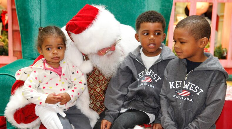 Santa Claus poses for photos with local children at the Upper Valley Mall on Saturday morning, Nov. 10, 2012, after arriving by chimney for his first appearance of the season.
Barbara J. Perenic/Springfield News-Sun