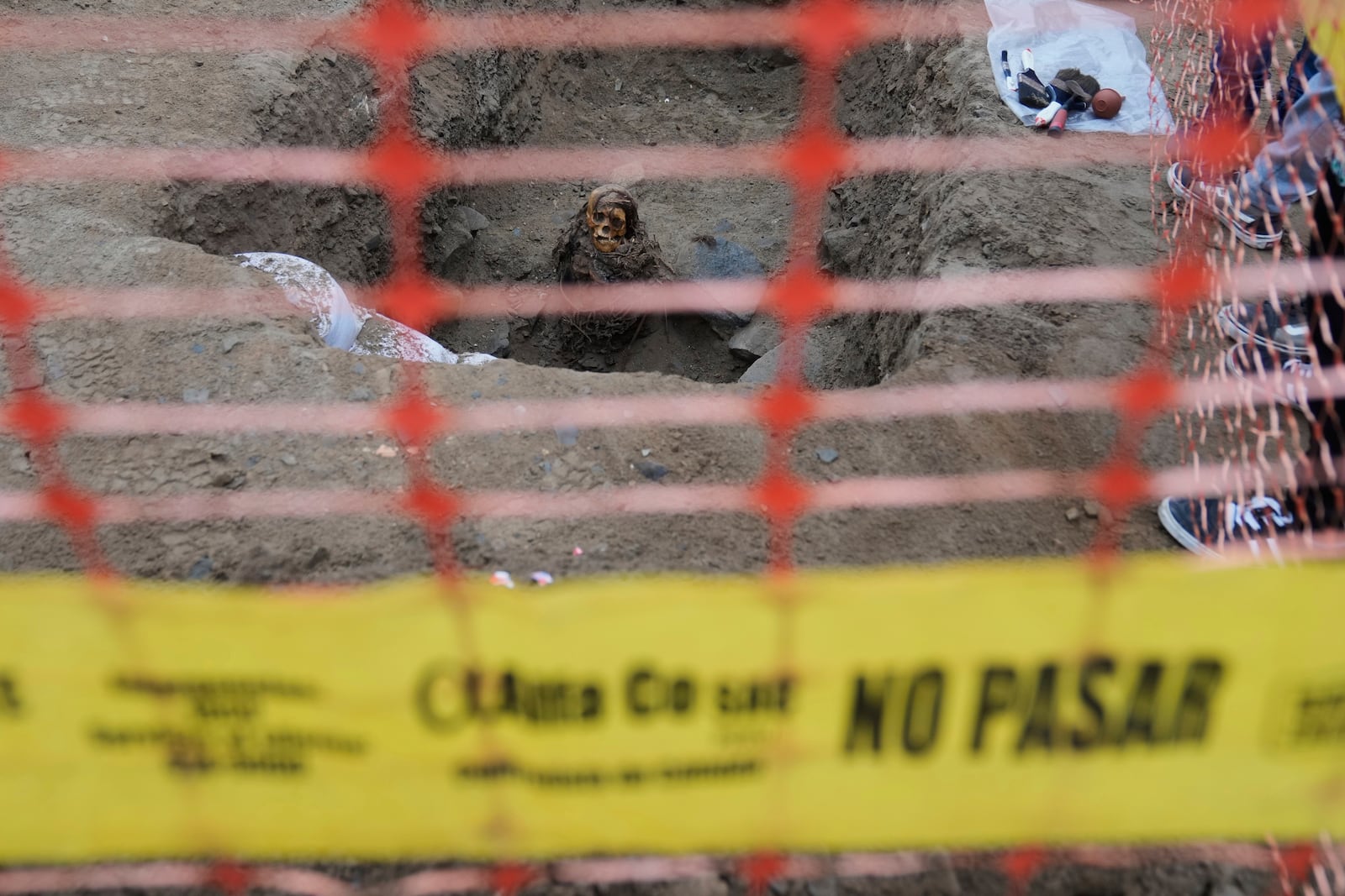 An ancient mummy which archeologists identify as female and from the pre-Inca Chancay culture is partially excavated after being discovered by city workers digging a natural gas line for the company Calidda in the district of Puente Piedra on the outskirts of Lima, Peru, Wednesday, June 18, 2025. (AP Photo/Martin Mejia)
