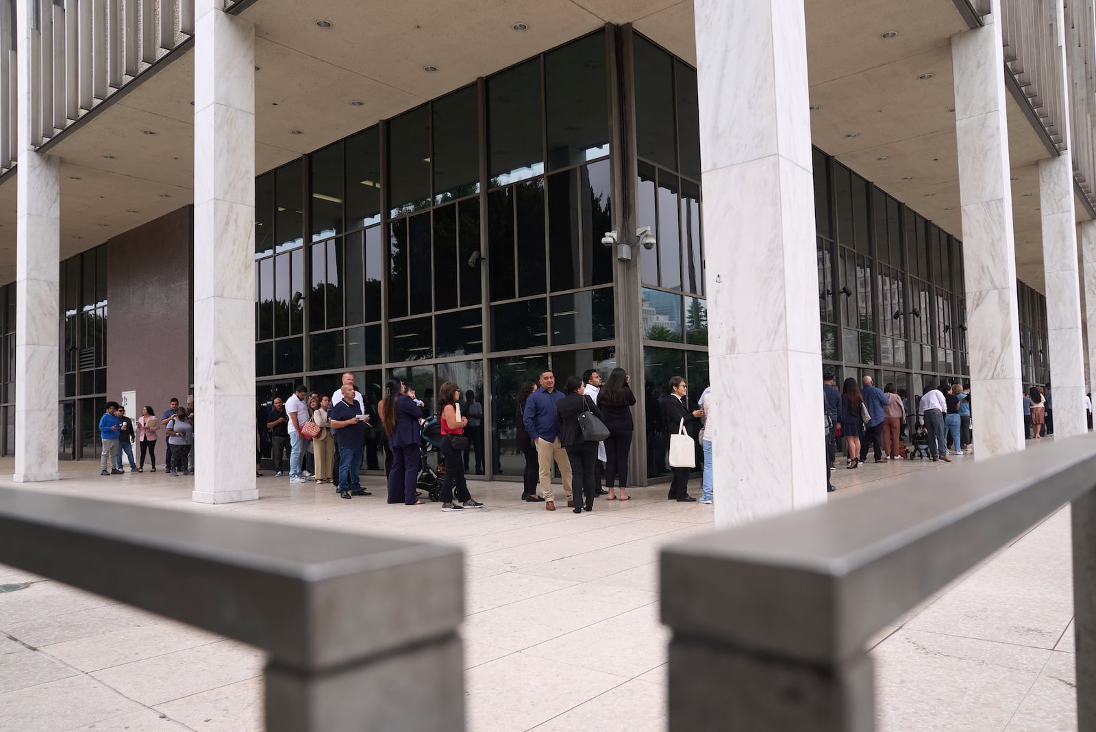 People line up outside the Los Angeles Federal Building in Los Angeles, housing the U.S. Immigration and Customs Enforcement (ICE) and U.S. Citizenship and Immigration Services (USCIS) on Wednesday, June 25, 2025. (AP Photo/Damian Dovarganes)