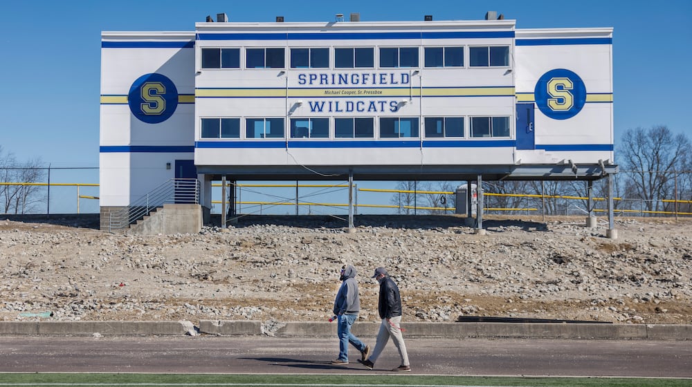 Andew Newcomb, left, and Kale Holbrook, installers with MegaLift, walk past bleachers that are being reconstructed on the track field at Springfield High School on Thursday, Feb. 26, 2026, in Springfield. Renovations of the track, scoreboard and bleachers are scheduled to be done by the end of summer. JOSEPH COOKE / STAFF