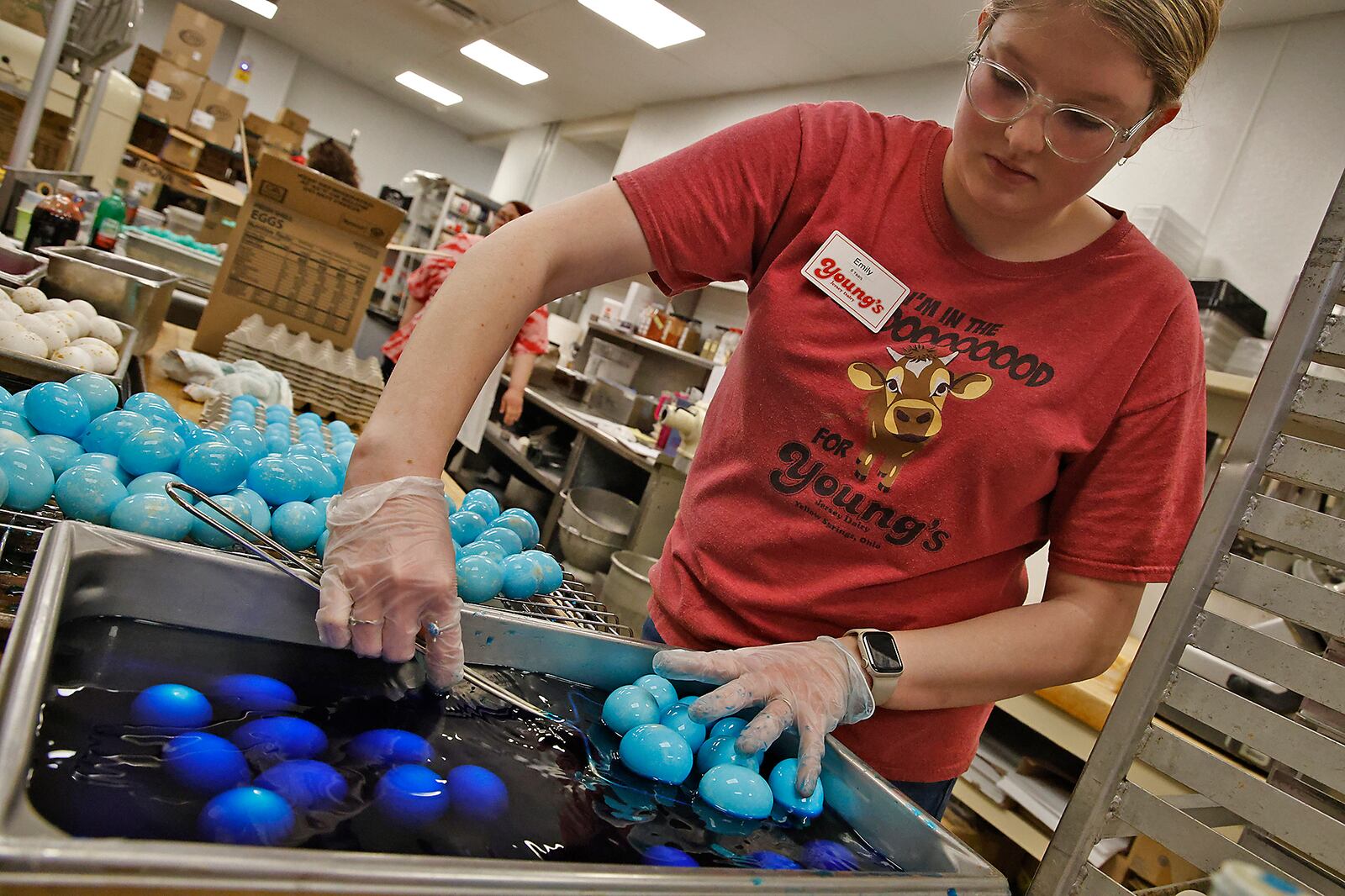 Emily Foss, an employee at Young's Jersey Dairy, works with three other employees to color over 10,000 eggs Tuesday, March 26, 2024 in the restaurant's kitchen. The eggs, which are baked in an oven instead of boiling, are for Young's 41st annual Easter Egg Hunt on Easter Sunday, March 31. BILL LACKEY/STAFF