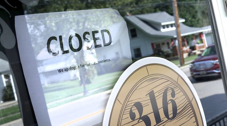 A closed sign on the front door of the 316 Tap & Barrel Grill in Medway. BILL LACKEY/STAFF