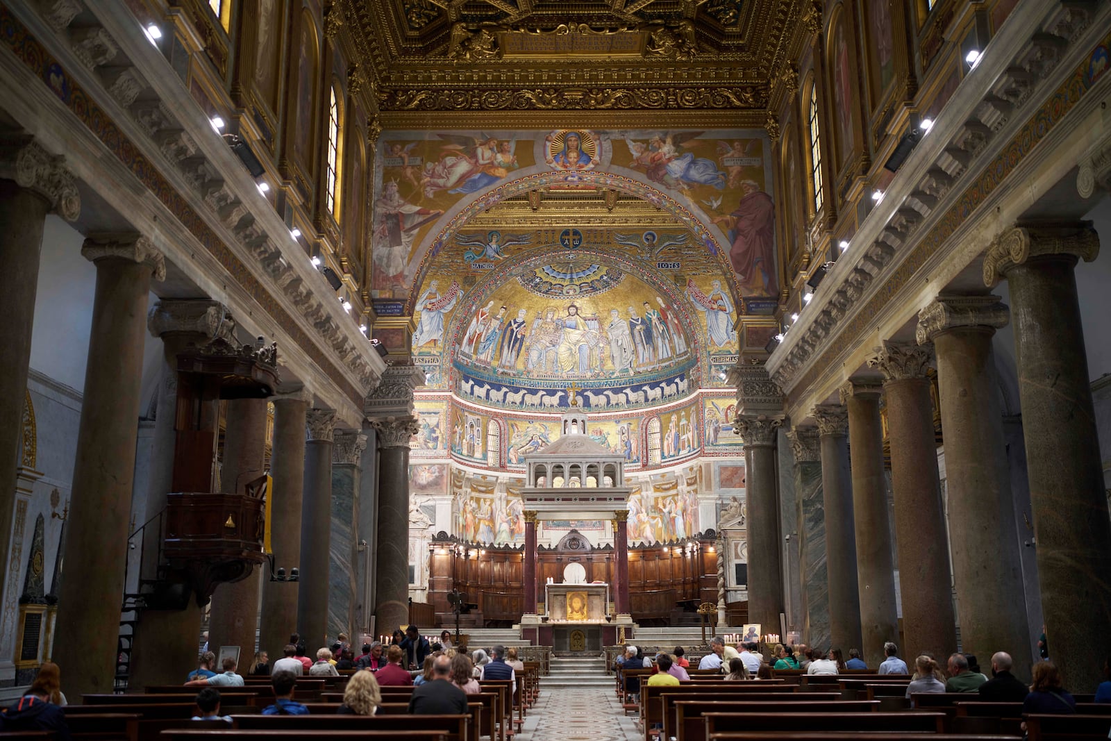 People attends a mass in Santa Maria in Trastevere church in central Rome, Sunday, May 4, 2025. (AP Photo/Alessandra Tarantino)