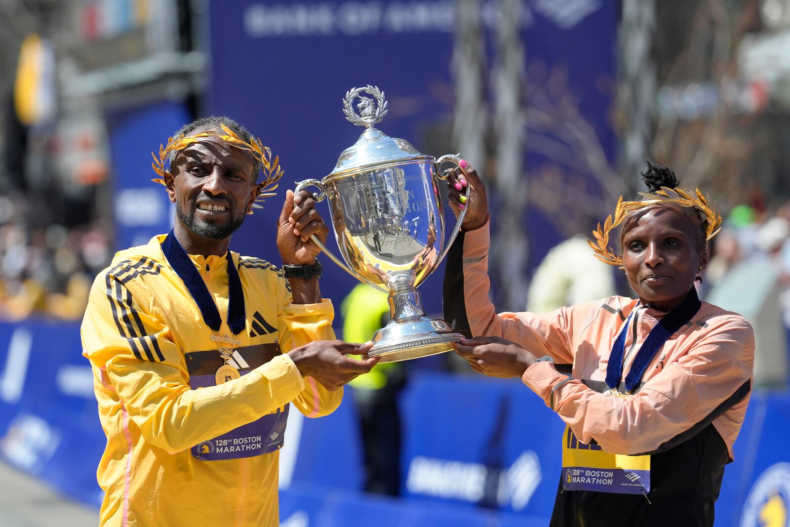 FILE - Sisay Lemma, of Ethiopia, left, winner of the men's division of the Boston Marathon, and Hellen Obiri, of Kenya, right, winner of the women's division of the race, hold the trophy on the finish line of the Boston Marathon, Monday, April 15, 2024, in Boston. (AP Photo/Steven Senne, File)