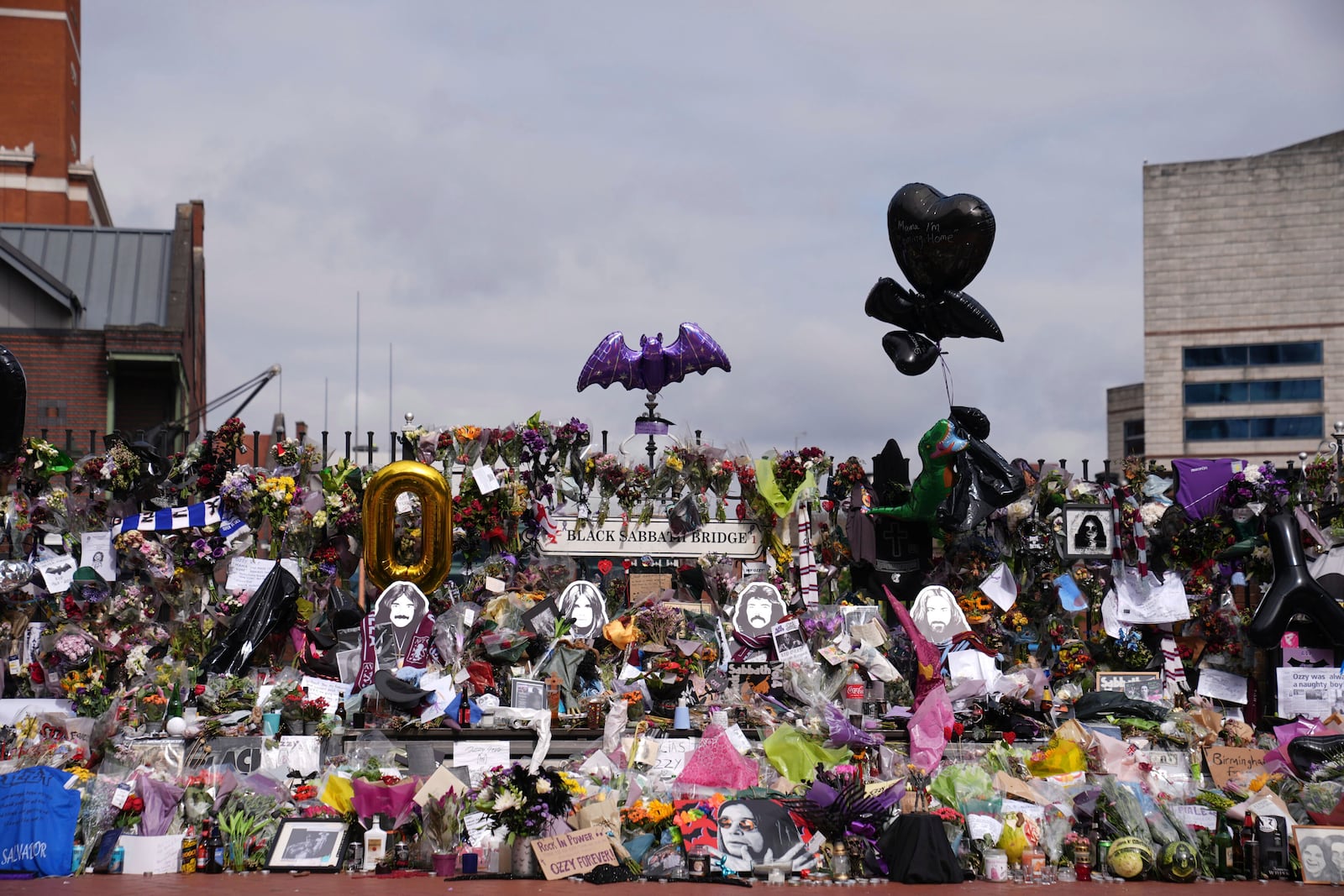 Floral tributes left at the Black Sabbath Bridge bench on Broad Street in memory of Black Sabbath frontman Ozzy Osbourne ahead of the funeral procession, in Birmingham, England, Wednesday July 30, 2025. (Joe Giddens/PA via AP)