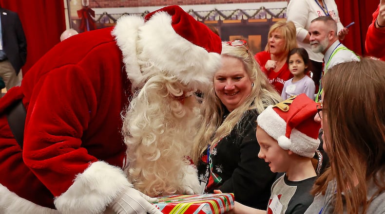 The Springfield Rotary Services to People with Disabilities awarded 11 special education teachers with Grants-To-Teachers program. Through this program, the Springfield Rotary provides recourses and other opportunities to children with disabilities. Here, Brogan, a guest at the Springfield Rotary Club's Christmas Party for Children with Disabilities, received a present from Santa at the party in December, which marked the Rotary's 100th annual Christmas party. BILL LACKEY/STAFF