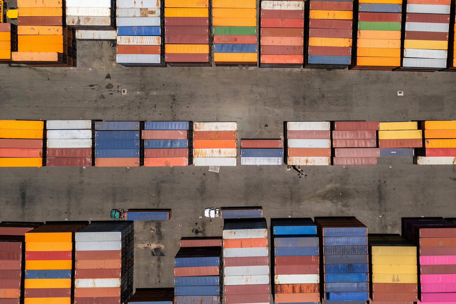 Trucks drive past shipping containers at the San Juan port, Puerto Rico, Thursday, May 8, 2025. (AP Photo/Alejandro Granadillo)