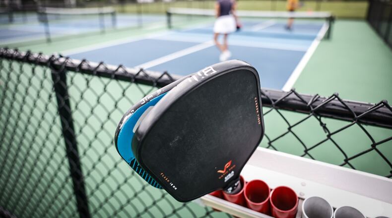 People play pickleball using paddles at the new courts at J.F. Kennedy Park in Kettering. JIM NOELKER/STAFF