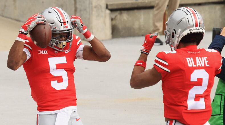 Ohio State's Garrett Wilson, left, celebrates a touchdown catch with Chris Olave in the first quarter against Nebraska on Saturday, Oct. 24, 2020, at Ohio Stadium in Columbus. David Jablonski/Staff