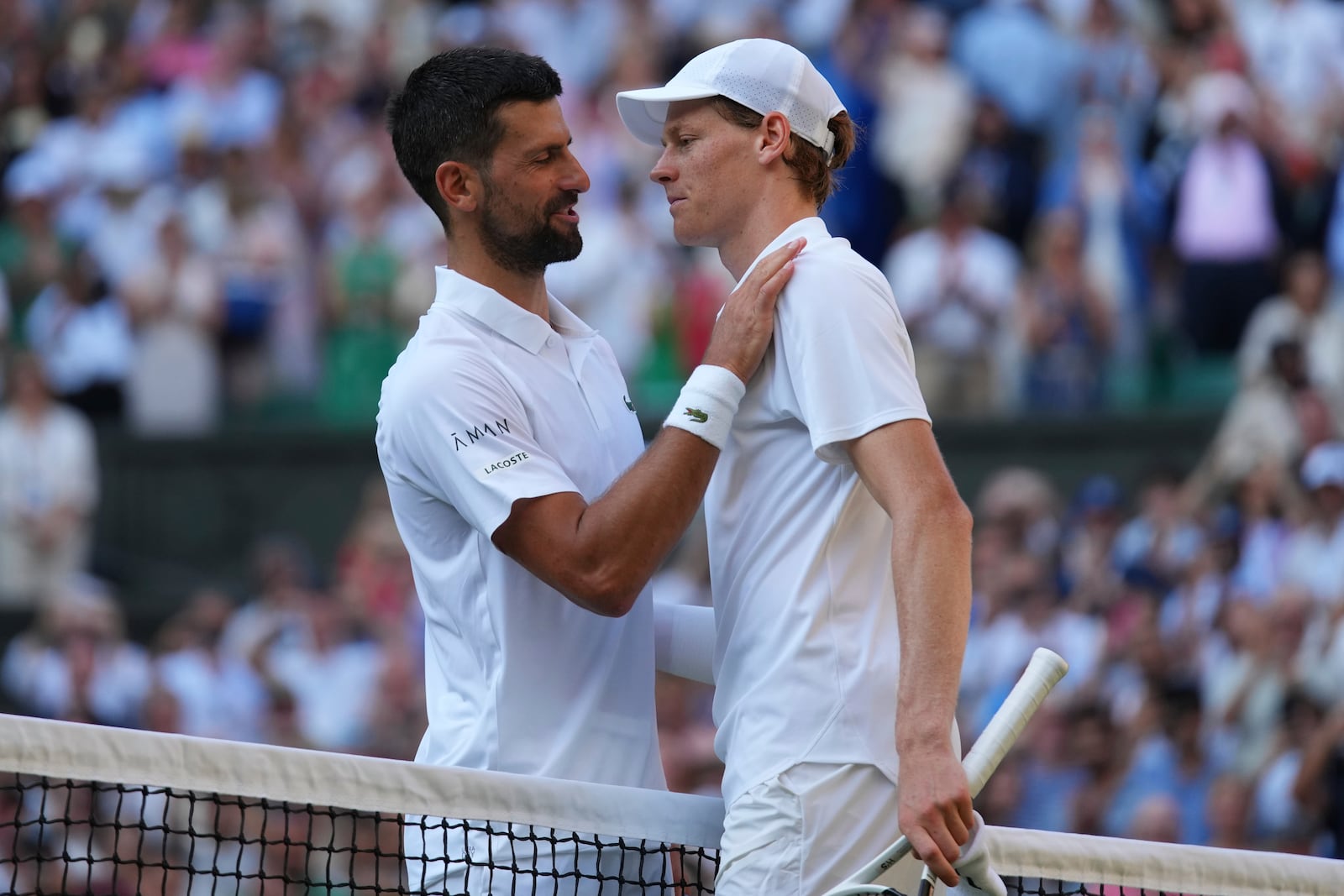 Jannik Sinner of Italy and Novak Djorkovic of Serbia chat after the men's semifinal singles match at the Wimbledon Tennis Championships in London, Friday, July 11, 2025.(AP Photo/Joanna Chan)