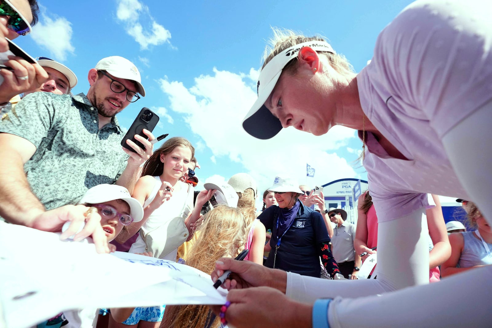 FILE - Nelly Korda, right, gives autographs after playing the third round of the Women's PGA Championship golf tournament, June 21, 2025, in Frisco, Texas. (AP Photo/LM Otero, File)