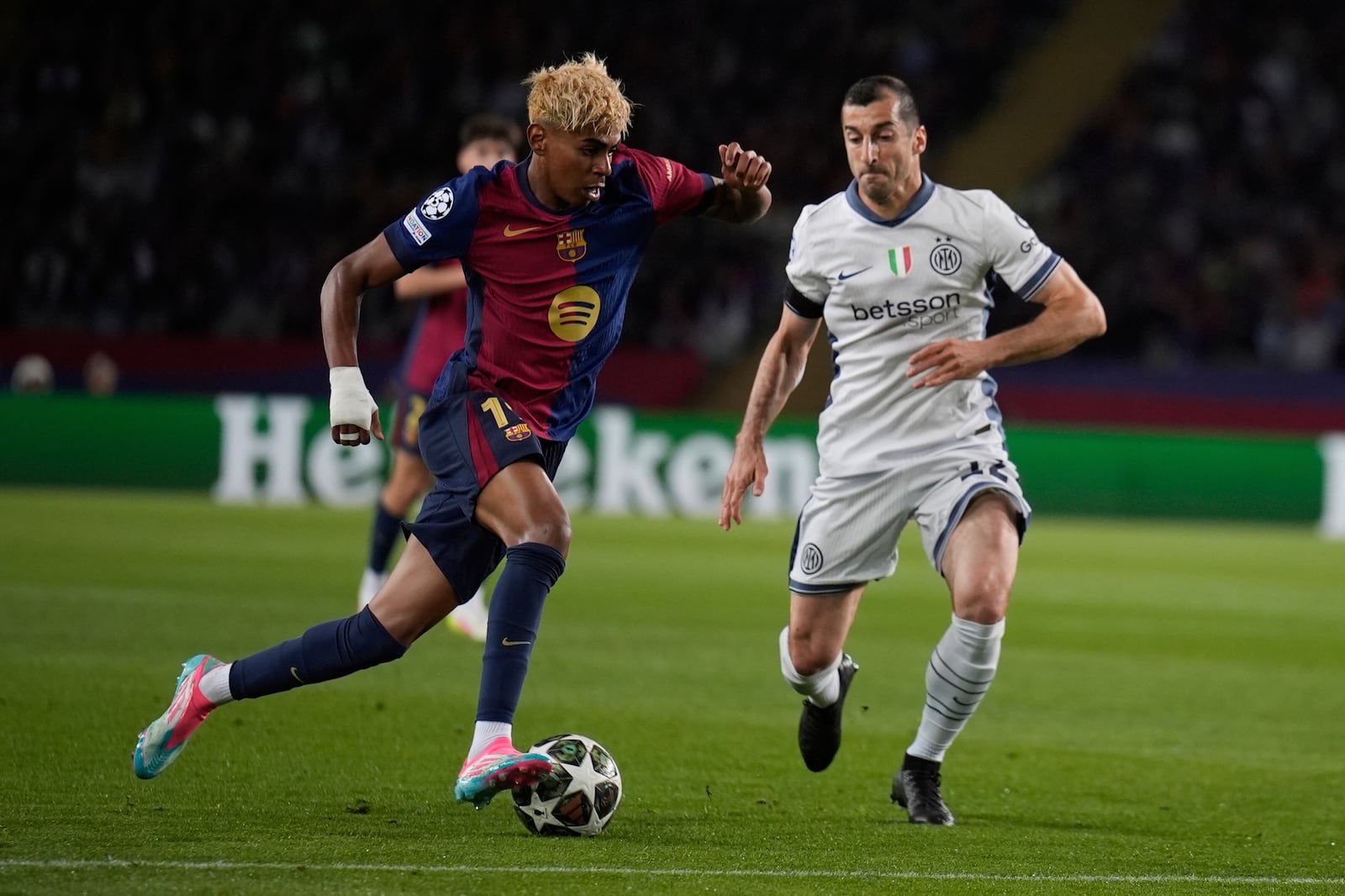 Barcelona's Lamine Yamal, left, and Inter Milan's Henrikh Mkhitaryan fight for the ball during the Champions League semifinal first leg soccer match between Barcelona and Inter Milan in Barcelona, Spain, Wednesday, April 30, 2025. AP Photo/Emilio Morenatti)