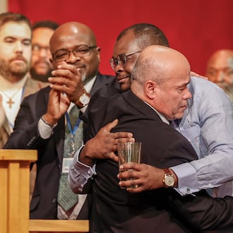 Pastor Jose Salas, front, hugs Viles Dorsainvil, co-founder and executive director of the Haitian Community Help & Support Center, during Here We Stand: Faith Leaders for Immigration Justice & Family Unity at St. John Missionary Baptist Church on Monday, Feb. 2, 2026, in Springfield. Pastors, faith leaders and community members gathered to pray and call for the extension of Temporary Protected Status which is scheduled to expire on Tuesday, Feb. 3, 2026. JOSEPH COOKE/STAFF