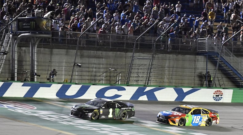 Kurt Busch crosses the finish line ahead of Kyle Busch (18) to win the NASCAR Cup Series auto race at Kentucky Speedway in Sparta, Ky., Saturday, July 13, 2019. (AP Photo/Timothy D. Easley)