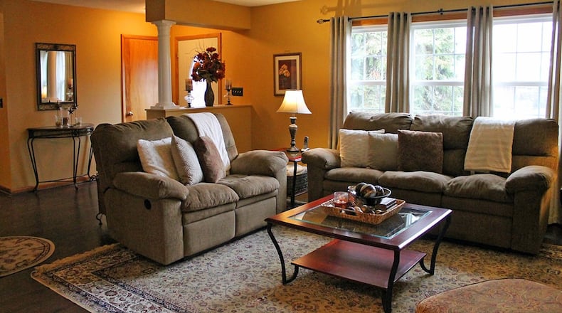 An oversized window bathes the formal living room in natural light.