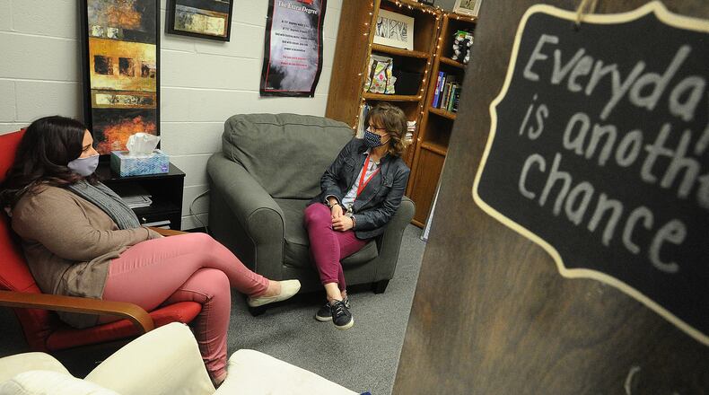 Troy MIddle School Guidance Counselors, Jennifer Augustine, left, and Kelly Leganik, consult with each other Monday, March 15, 2021. Augistine has many positive signs hanging on her office door. MARSHALL GORBY\STAFF