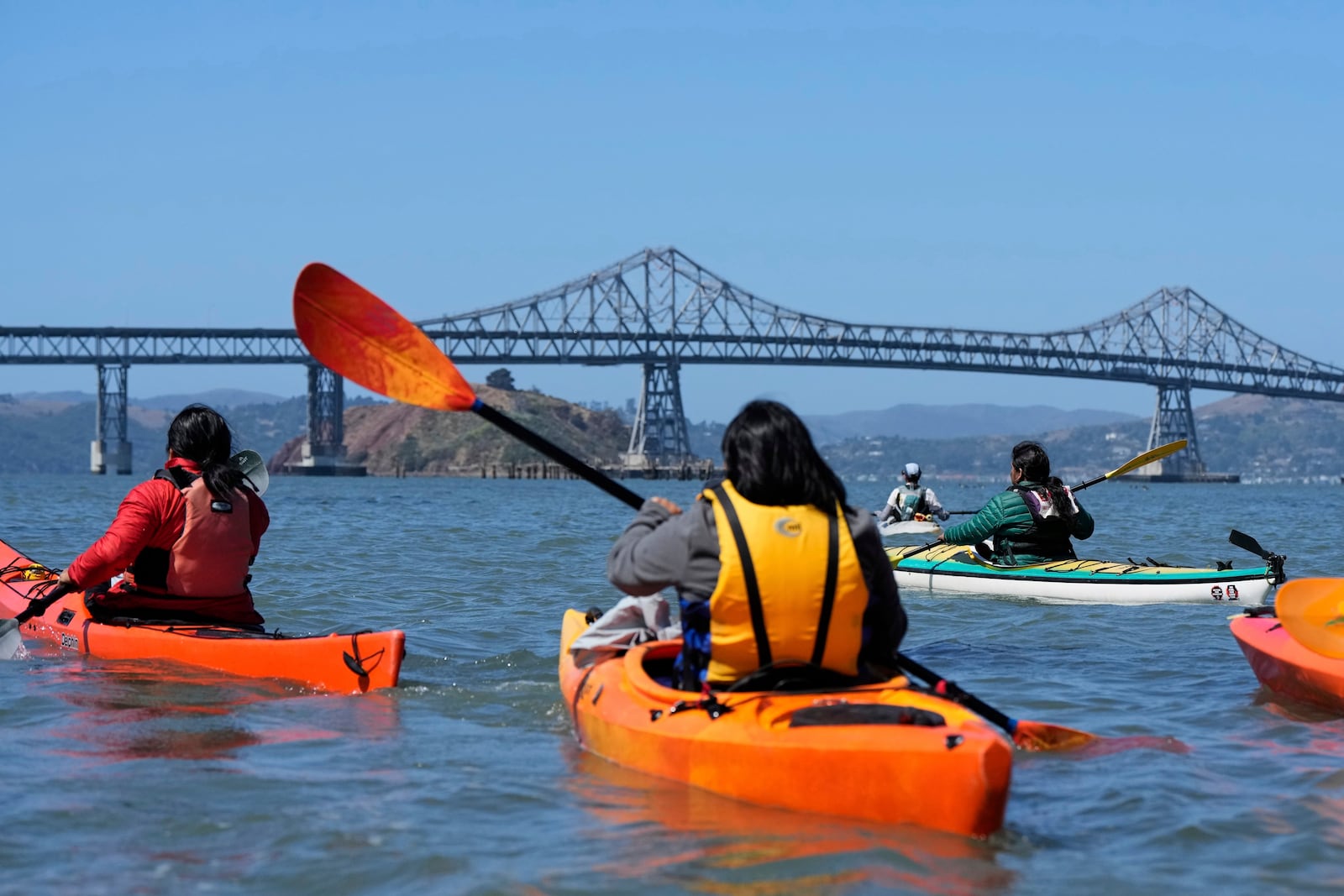 A delegation of Indigenous leaders from Ecuador kayak in the San Francisco Bay to take a closer look at the Chevron Long Wharf, Thursday, June 19, 2025, in Richmond, Calif. (AP Photo/Godofredo A. Vásquez)