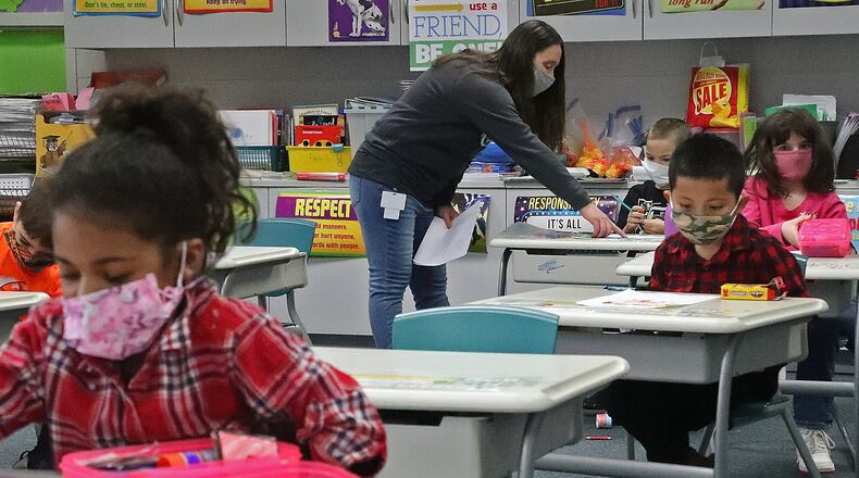 With masks and desks spaced apart, students at Simon Kenton Elementary work on classwork Friday, Feb. 19, 2021. BILL LACKEY/STAFF