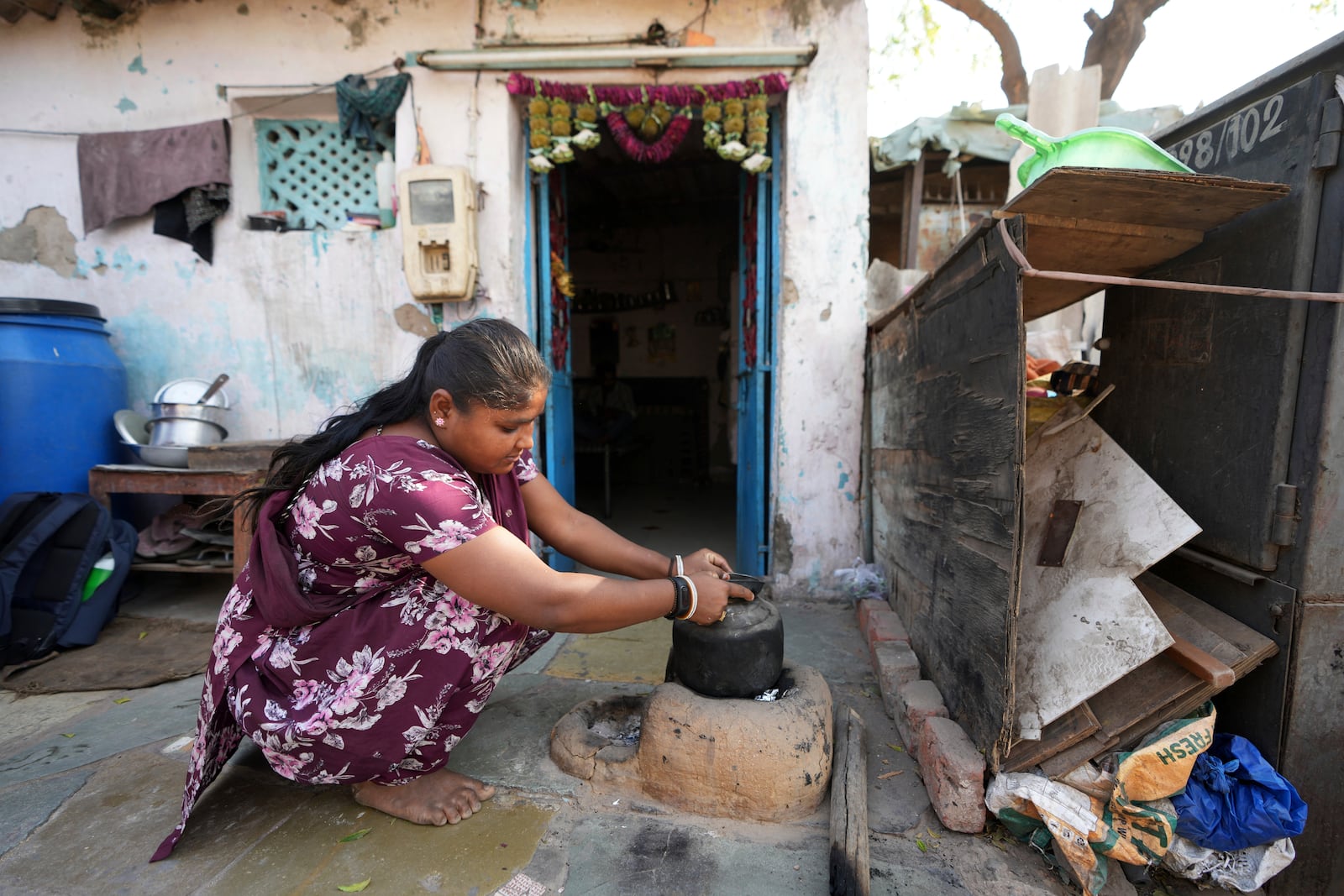 Puja Vanzara, wearing a wristwatch-style health monitor to study how heat affects vulnerable communities, works at her house in Vanzara Vas in Ahmedabad, India, Wednesday, April 2, 2025. (AP Photo/Ajit Solanki)