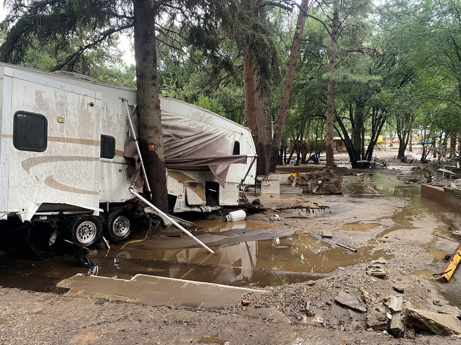 In this photo provided by Jean Meairs, damage from a flood that tore through the Riverview RV Park along the Rio Ruidoso is seen, Tuesday, July 8, 2025, in Ruidoso, N.M. (Jean Meairs via AP)