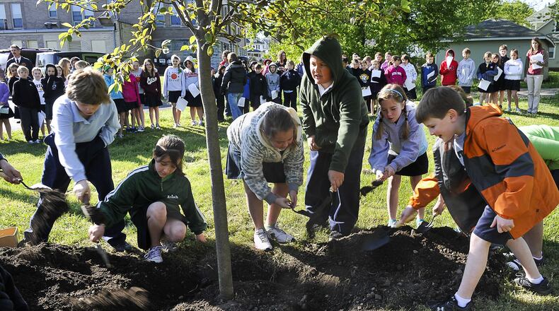 Students at St. Bernard Elementary plant a Chokecherry tree in a grassy lot behind the school Friday during an Arbor Day ceremony in 2020. Students from the school talked about the history of Arbor Day and read poetry about trees, and Springfield city officials read a proclamation during the ceremony. Staff photo by Bill Lackey