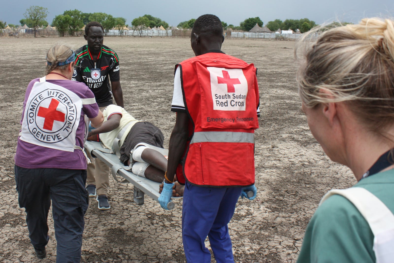 Medical staff with the International Committee of the Red Cross (ICRC) and South Sudan Red Cross carry a weapon-wounded patient in Akobo, South Sudan, Saturday, May 24, 2025. (AP Photo/Joseph Falzetta)