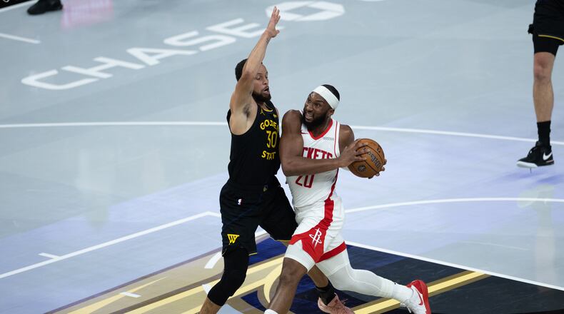 Houston Rockets guard Josh Okogie is guarded by Golden State Warriors guard Stephen Curry during the first half of an Emirates NBA Cup basketball game Wednesday, Nov. 26, 2025, in San Francisco. (AP Photo/Benjamin Fanjoy)