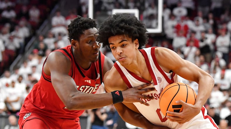 Louisville guard Mikel Brown Jr., right, attempts to get past North Carolina State guard Tre Holloman, left, during the second half of an NCAA college basketball game in Louisville, Ky., Monday, Feb. 9, 2026. (AP Photo/Timothy D. Easley)
