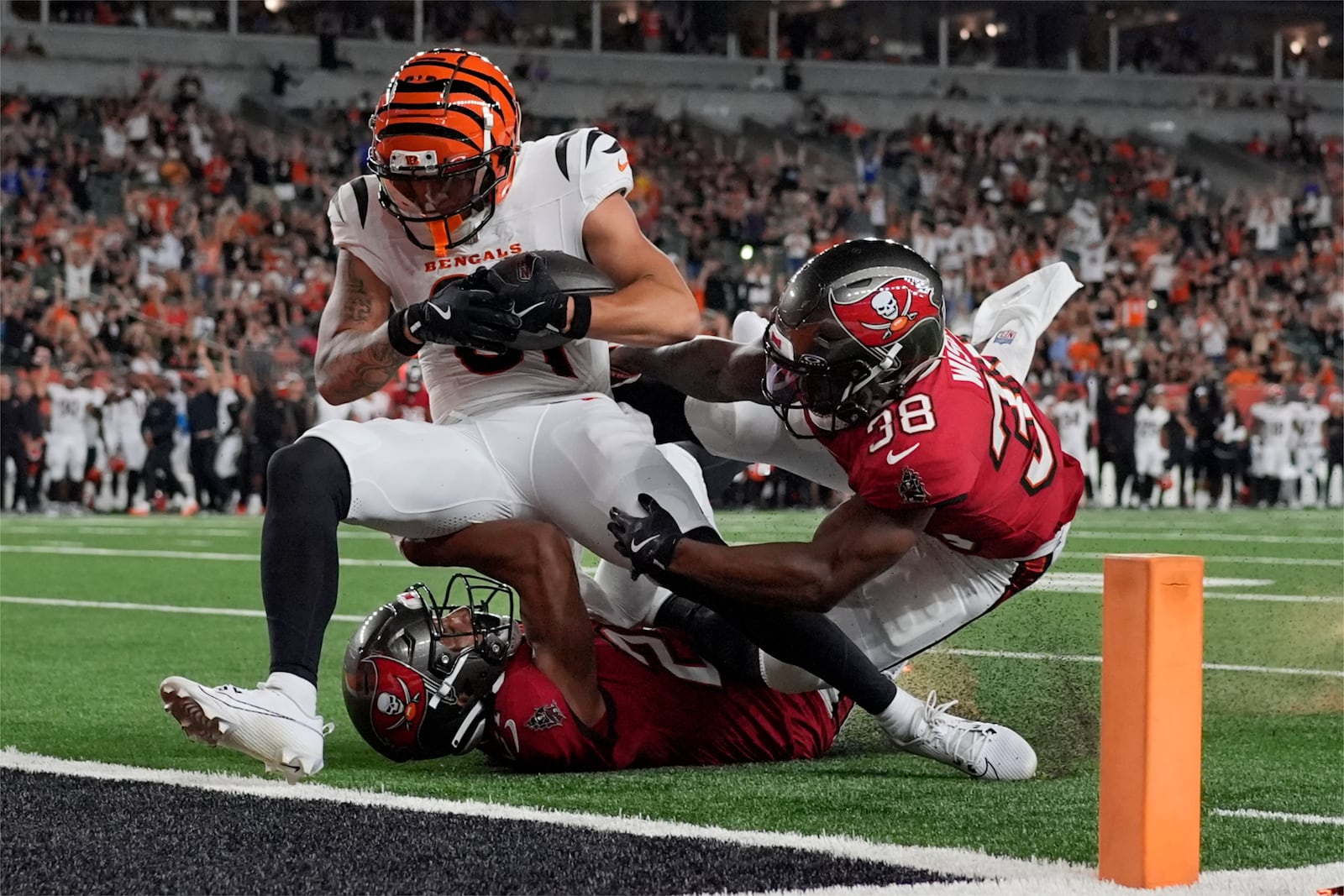 Cincinnati Bengals wide receiver Jermaine Burton, top left, scores a touchdown ahead of Tampa Bay Buccaneers safety Rashad Wisdom (38) in the second half of an NFL preseason football game Saturday, Aug. 10, 2024, in Cincinnati. (AP Photo/Carolyn Kaster)