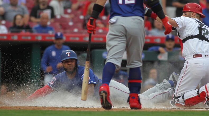 The Rangers' Elvis Andrus steals home ahead of the tag by Reds catcher Curt Casali in the first inning on Friday, June 14, 2019, at Great American Ball Park in Cincinnati.